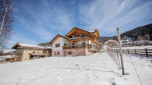 una casa en la nieve frente a una valla en Ferienhaus Sternhof, en Mieders