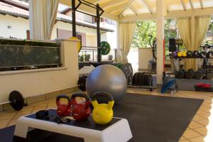 een kamer met een fitnessruimte met een bal en halters bij Hotel Rosenblatt in Cervia