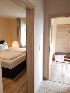 Habitación con dormitorio con cama y espejo. en Apartments by Gasthof Bucksande en Apen