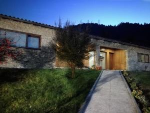 a stone house with a tree in the yard at Cottage, Casa do Laranjal - Near Gerês in Geres