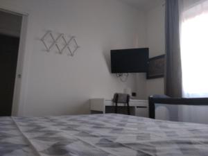 a bedroom with a bed and a flat screen tv at B&B Gaslini & Mare (anche con uso cucina) in Genoa