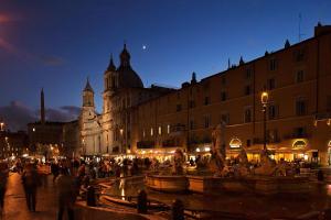 ローマにあるCasa de' Coronari Suitesの夜の街の噴水を歩く人々