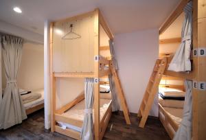 a room with three bunk beds in a room at Trip & Sleep Hostel in Nagoya