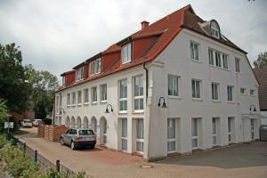 a large white building with a car parked in front of it at Apartment 11 - Maisonette in Heiligenhafen