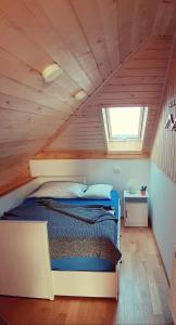 1 dormitorio con 1 cama en una habitación de madera en Prenočišča Angelin hram, Tiny Apartments en Markovec