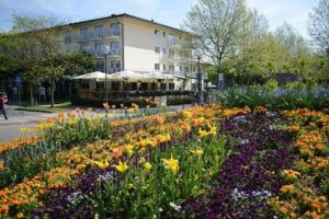 um jardim de flores em frente a um edifício em Hotel Dein Franz em Bad Füssing