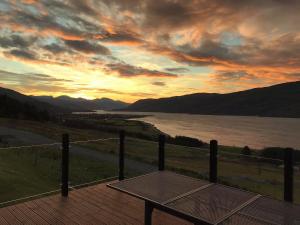 una mesa en una terraza con vistas al lago en Croft No.8 Bed & Breakfast, en Ullapool