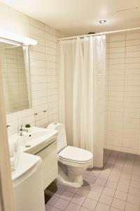 a white bathroom with a toilet and a sink at Forenom Serviced Apartments Oslo Royal Park in Oslo