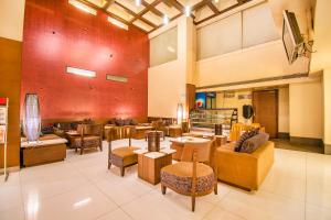 a large lobby with tables and chairs and a couch at Hotel Sadanand Regency in Pune