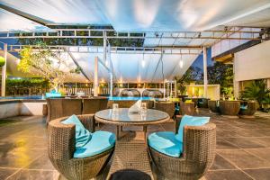 a patio with a table and chairs and a bar at Hotel Sadanand Regency in Pune