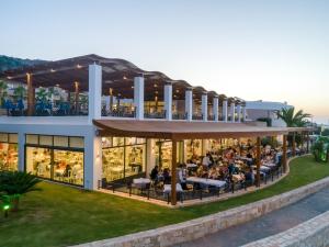 budynek z ludźmi siedzącymi przy stolikach przed nim w obiekcie Grand Hotel Holiday Resort w mieście Hersonissos