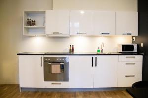 cocina con armarios blancos y microondas en Forenom Serviced Apartments Oslo Royal Park, en Oslo