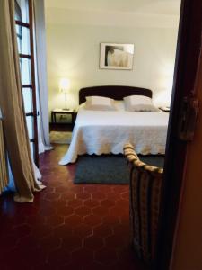 a bedroom with a bed with a white bedspread at La Gracette in Aix-en-Provence