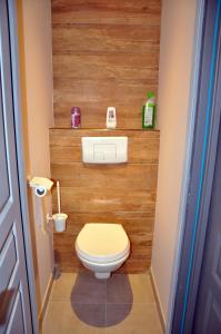 a bathroom with a toilet with a wooden wall at Les mouettes - la paix du bord de Seine in Berville-sur-Seine