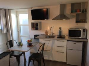 a kitchen with a small table and a microwave at La pierre du petit'hom in Goxwiller