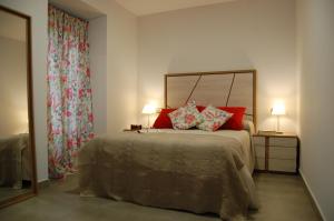 a bedroom with a large bed with red pillows at ALHAJAS DE CORDOBA in Córdoba