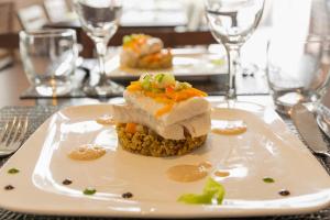 ein Stück Essen auf einer weißen Platte auf einem Tisch in der Unterkunft Hôtel du Golf Saint-Laurent in Ploemel