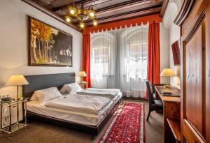 um quarto com uma cama e uma secretária e uma cama sidx sidx em Hotel Adler em Ingolstadt