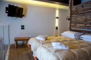 2 camas en una habitación con TV en la pared en Hotel Dufour, en Gressoney-la-Trinité