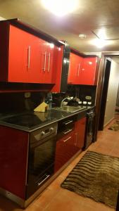 uma cozinha com armários vermelhos e um balcão preto em Pyramids Porto Ain Sokhna em Ain Sokhna