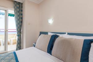 A bed or beds in a room at Galaxy Beach Hotel Alanya