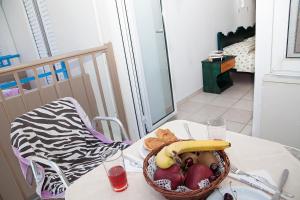 - un bol de fruits sur une table avec une chaise dans l'établissement Hotel Athinoula, à Kefalos
