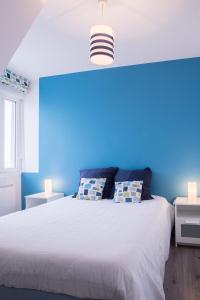 a bedroom with a bed and a lamp on the wall at Résidence La Plage d'Or in Vierville-sur-Mer