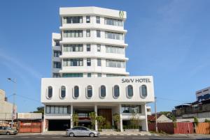 um edifício branco alto com um cartaz em SAVV HOTEL em George Town