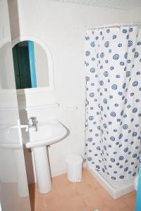 een badkamer met een wastafel en een douchegordijn bij Hotel Athinoula in Kefalos