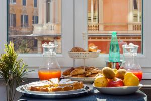 une table recouverte de assiettes de nourriture et de fruits dans l'établissement Flat 285 La Suite, à Rome