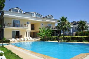 a villa with a swimming pool in front of a house at Kemer Residence in Kemer