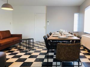 een eetkamer met een tafel en stoelen bij 't Hoekske in Merkem