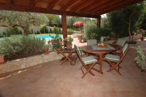 a patio with a table and chairs and a pool at Villa Paladino in Castellammare del Golfo