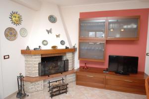 a living room with a fireplace and a flat screen tv at Villa Paladino in Castellammare del Golfo