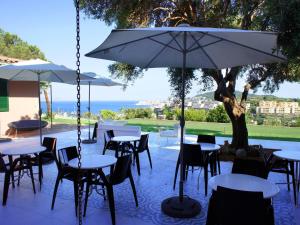 a patio with tables and chairs and an umbrella at Villa Di Papa' in Gaeta