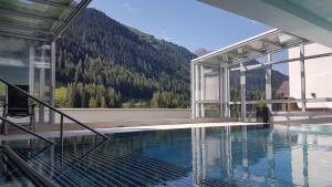 a large swimming pool in front of a large building at Hotel Nassereinerhof in Sankt Anton am Arlberg