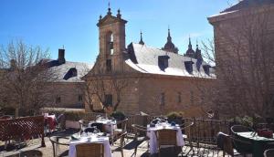 um pátio com mesas e cadeiras em frente a um edifício em Apartamento en Centro Historico de San Lorenzo de El Escorial em San Lorenzo de El Escorial