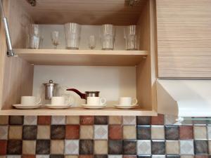 a cupboard with cups and dishes and glasses on it at Lily's Apartment in Yerevan