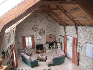 ein Wohnzimmer mit Sofas und einer Steinmauer in der Unterkunft Le Bois Chef D'Ane in Collinée