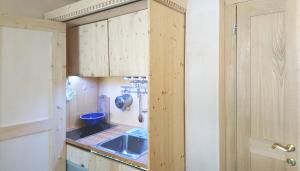 una piccola cucina con armadi in legno e lavandino di Ugo Architect's Lodge Classic a Bolzano