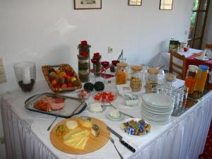 una mesa blanca con comida y platos. en Gästehaus Trahasch im Adelshof, en Endingen am Kaiserstuhl