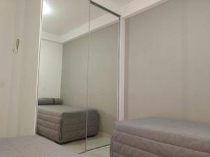 a bedroom with a mirror and a bed and a ottoman at Apartamento Praia Grande 301 in Ubatuba