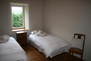 a bedroom with two beds and a window at Ty Goonvrea in Louargat