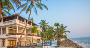 a house on the beach with palm trees at 36 Palms Residency - Sea View Villa in Cochin