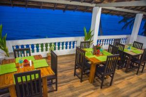 a restaurant with tables and chairs and the ocean at 36 Palms Residency - Sea View Villa in Cochin