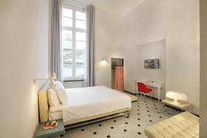 
a bedroom with a white bed and white walls at Hotel Le Nuvole Residenza d'Epoca in Genoa
