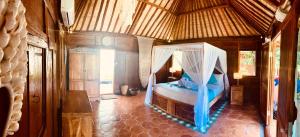 a bedroom with a bed with a mosquito net at Kubu Kangin Resort in Amed +84 photos