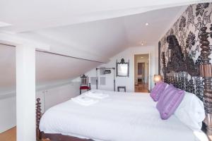 リスボンにあるTravelingToLisbon 120 - Alfamaのベッドルーム(紫色の枕が付いた大きな白いベッド付)