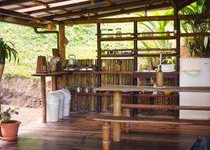 einen Tisch und Bänke in einem Pavillon mit Pflanzen in der Unterkunft Amazonita Ecolodge in Dos Brazos