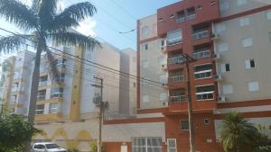 a row of apartment buildings with a palm tree at Apartamento Praia Grande 301 in Ubatuba